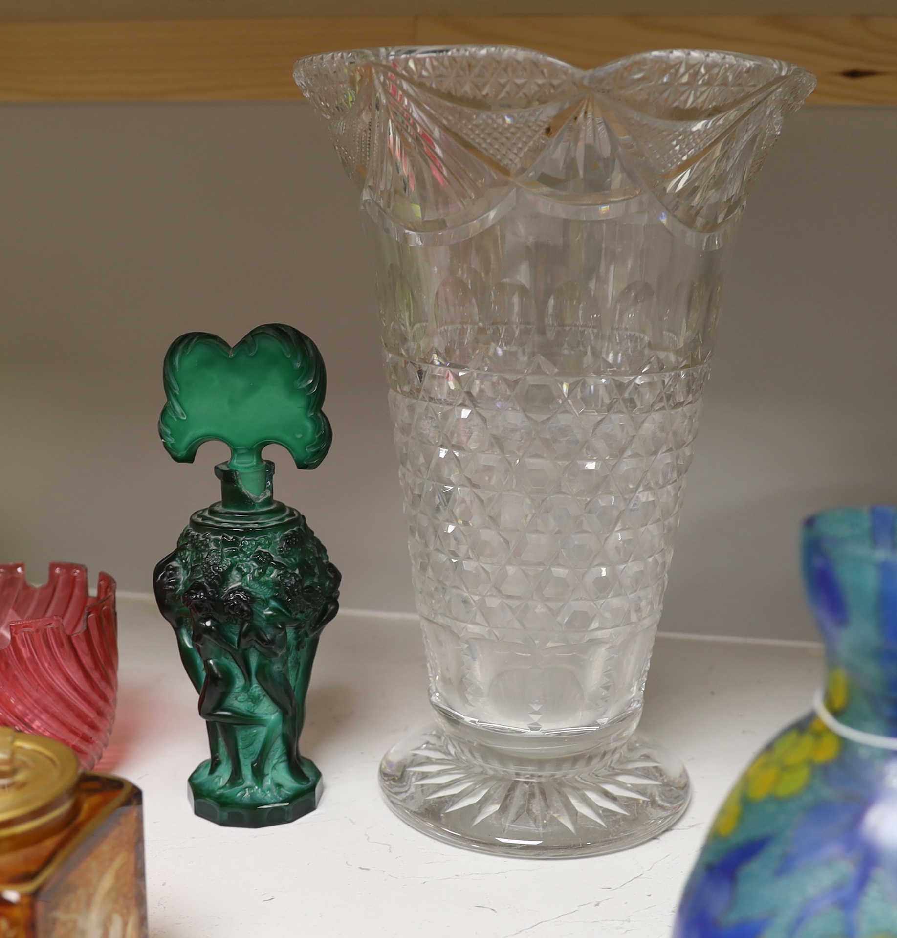 A quantity of various coloured and clear glass including an Art Deco figural scent bottle, cranberry glass vases and a yellow glass jar and cover, largest 30cm high